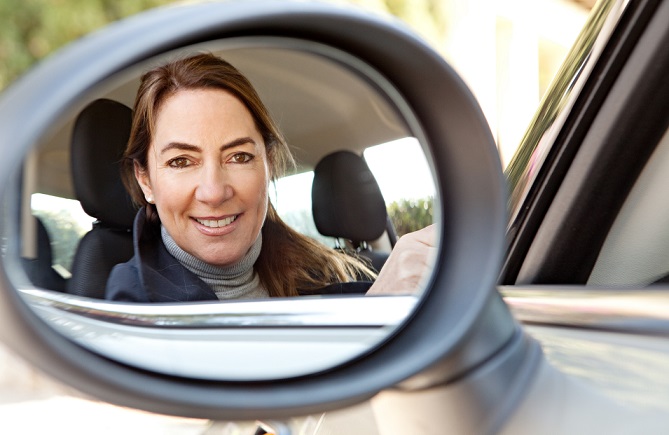 woman-looking-into-car-mirror