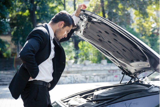 Man looking at car engine - when to buy a new car