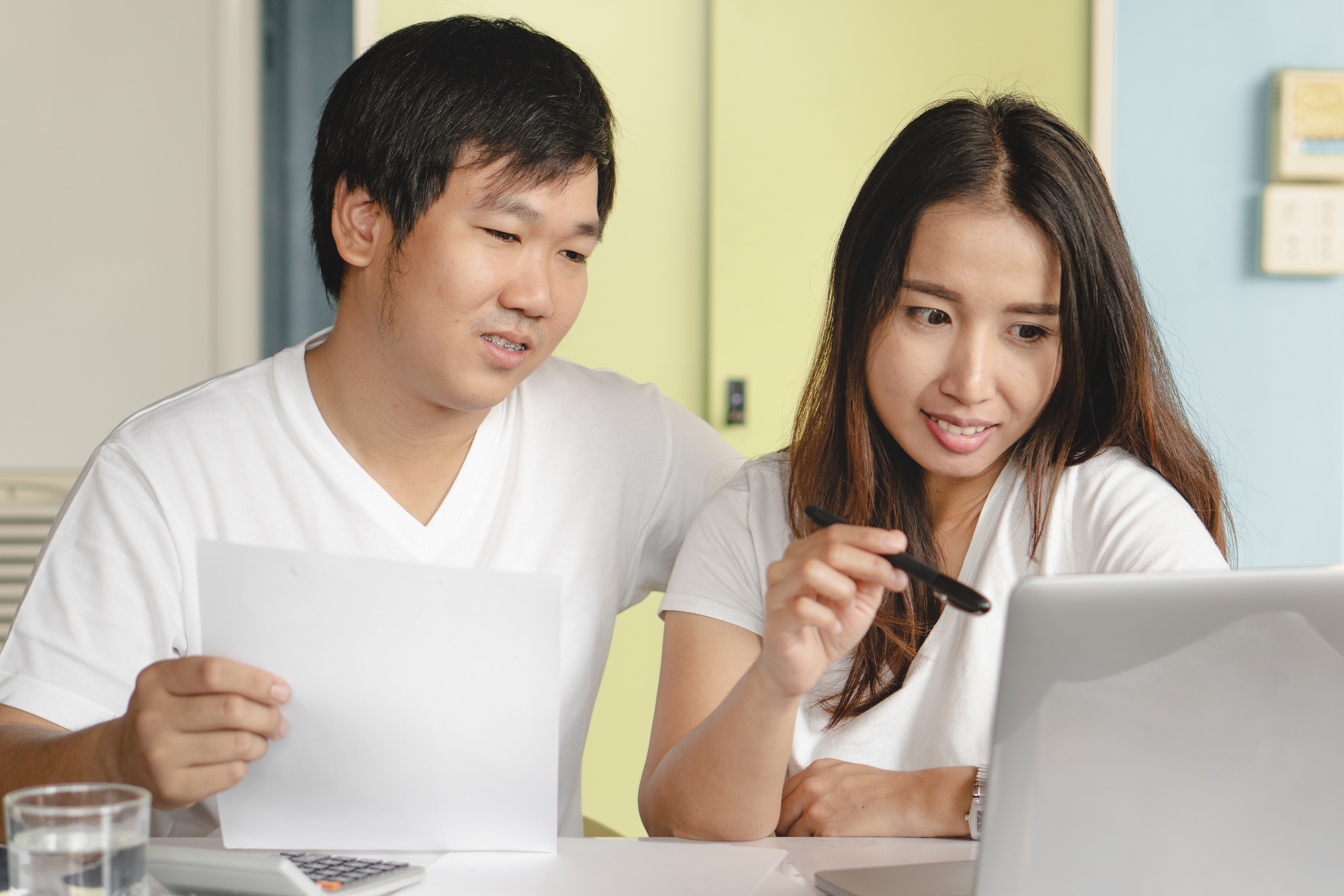 Young Asian couple doing finances on computer