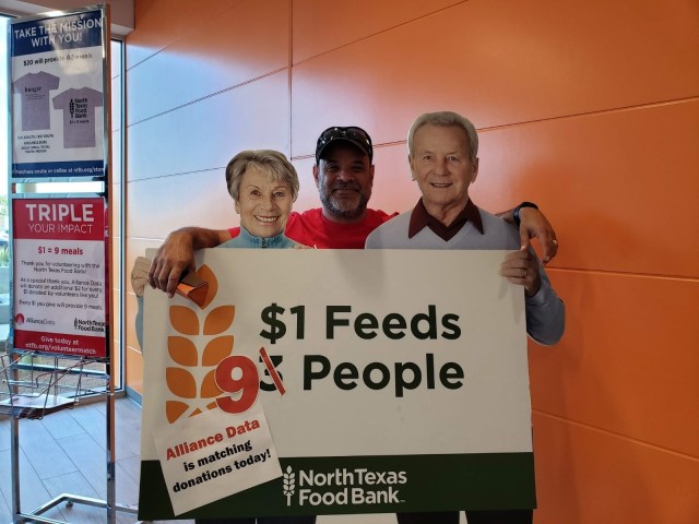 Volunteer standing with food bank cutout