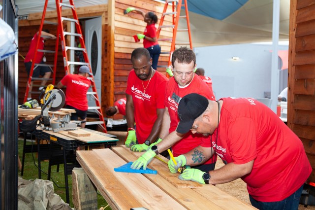 Volunteers measure siding for tiny houses for veterans