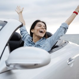 Woman waving from convertible