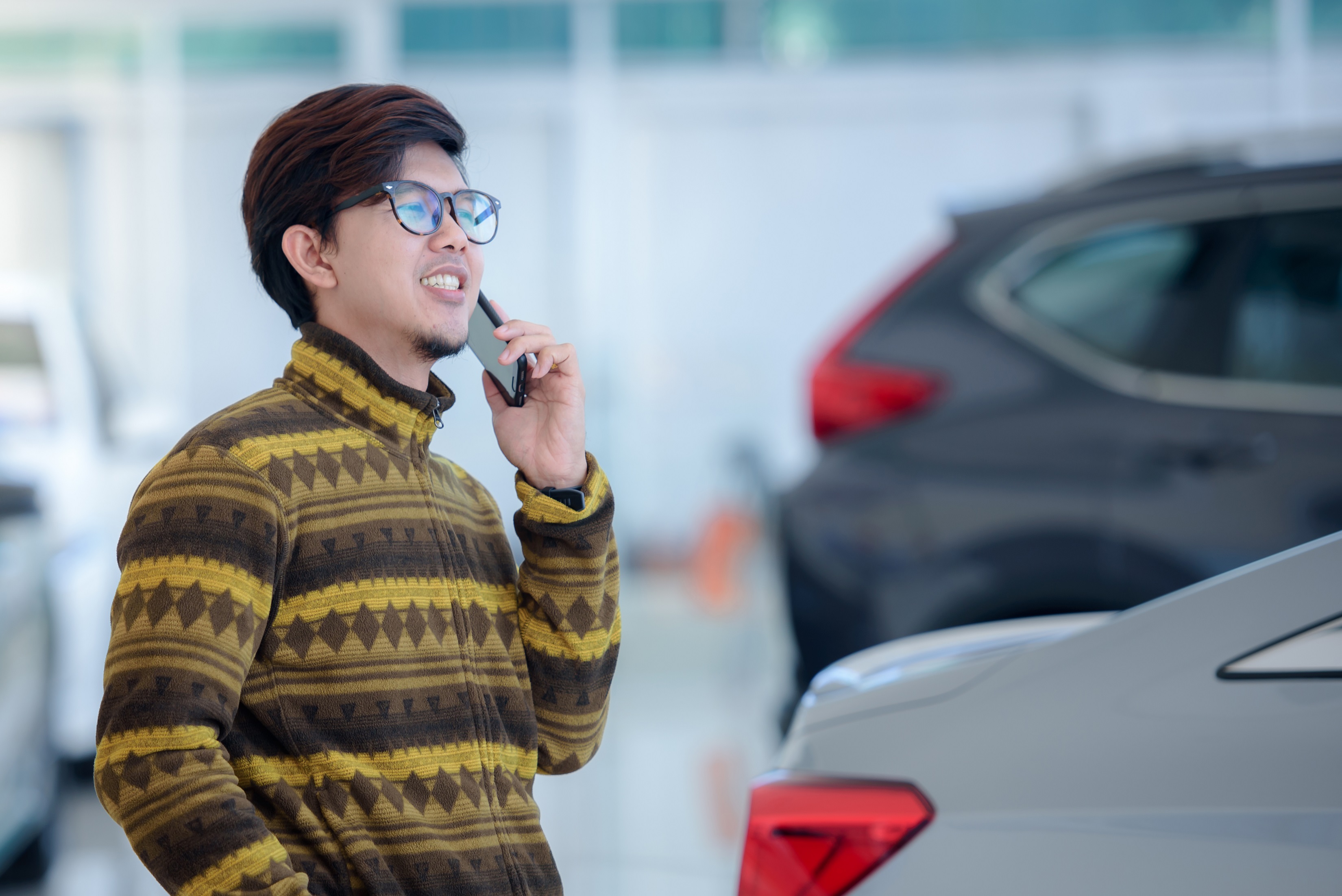 Man car buying on phone in showroom