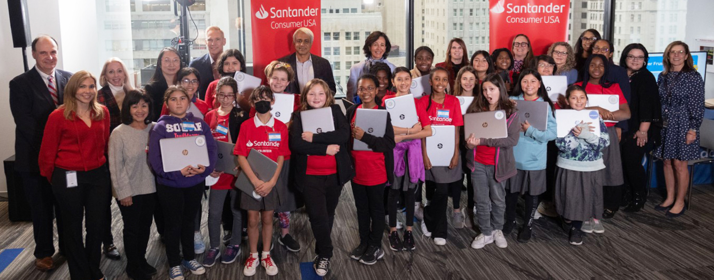 Santander Consumer USA Inc. Foundation members with children receiving laptops