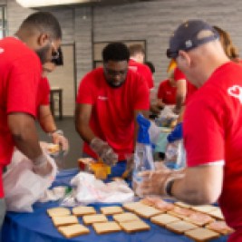 Group of Santander Consumer USA volunteers making sandwiches for nonprofit organizations.