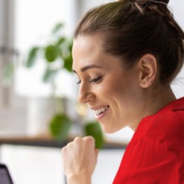 Person smiling and working at a laptop computer.