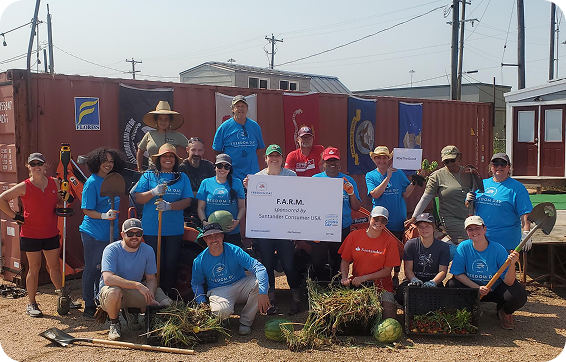 A group of Santander Consumer USA volunteers at a NorthTexas Food Bank event holding an over-sized donation check.